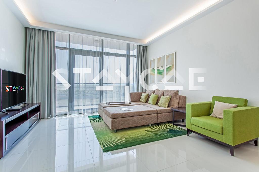 - un salon avec un canapé et une chaise dans l'établissement Staycae Holiday Homes - Celestia, à Dubaï