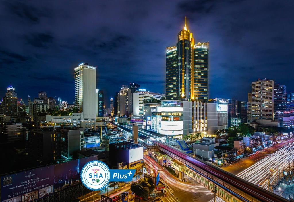 a city at night with skyscrapers and traffic lights at Grande Centre Point Hotel Terminal21 - SHA Extra Plus in Bangkok