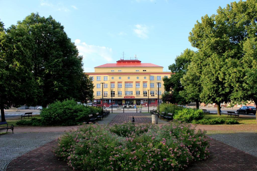 een groot geel gebouw met een rood dak bij Mini Hotel Akord in Ostrava