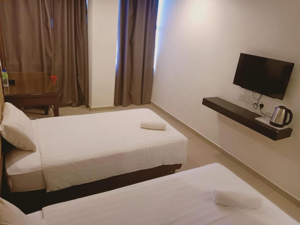 Postel nebo postele na pokoji v ubytování T Hotel Anggerik