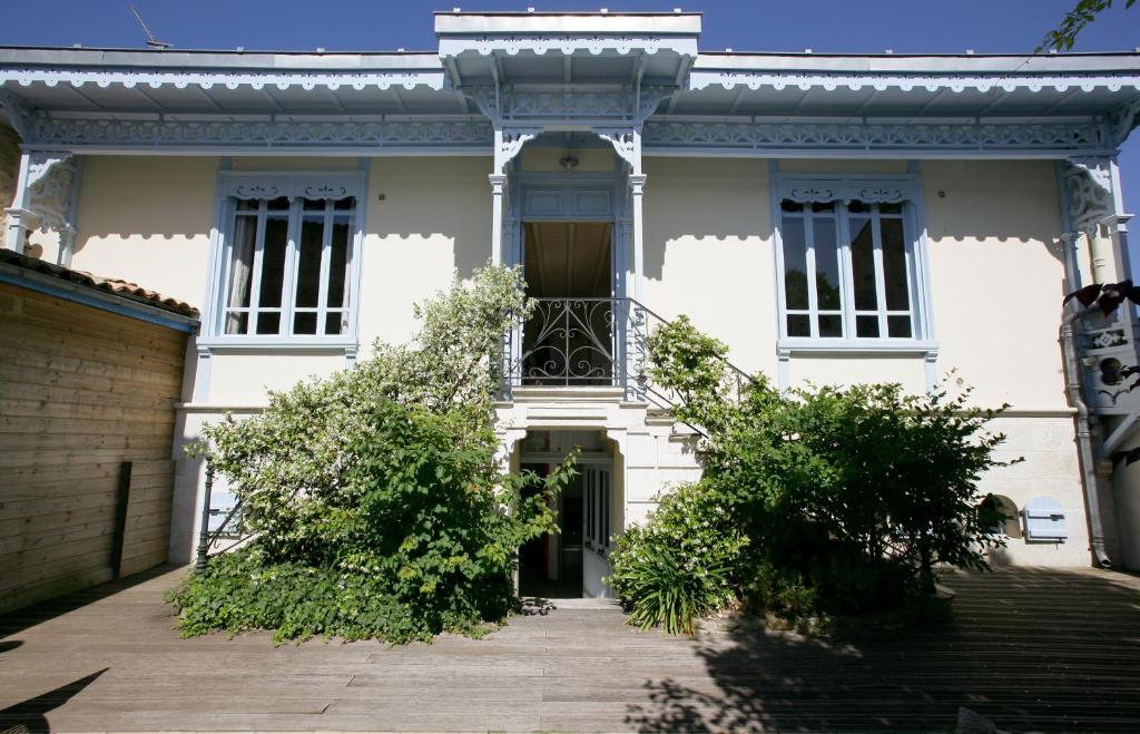 Cette maison blanche dispose d'un portail et d'un balcon. dans l'établissement La Maison Balnéaire, à Sainte-Marie de Ré