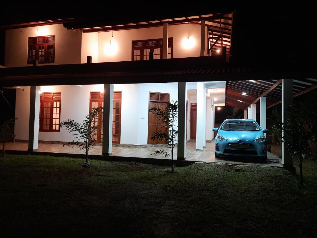 um carro estacionado em frente a uma casa à noite em Muthuarana Villa Matara em Matara