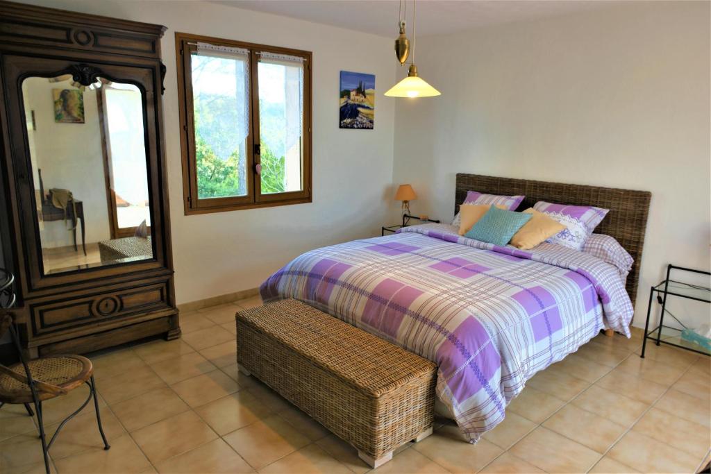 a bedroom with a bed and a mirror and a chair at Chambre d hôtes de la Louve in Fréjus