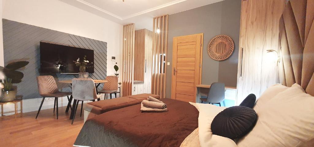 a bedroom with a bed and a dining room at DK Premium UkielPark in Olsztyn