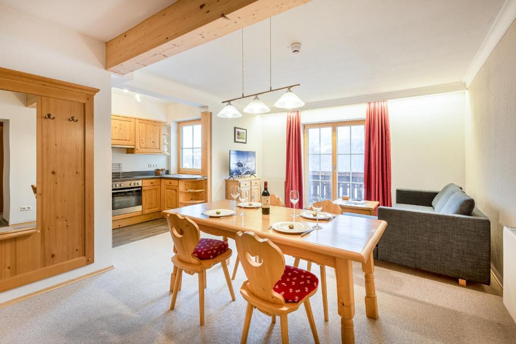 uma cozinha e sala de estar com uma mesa de madeira e cadeiras em Apparthaus Sonnenberg em Haus im Ennstal