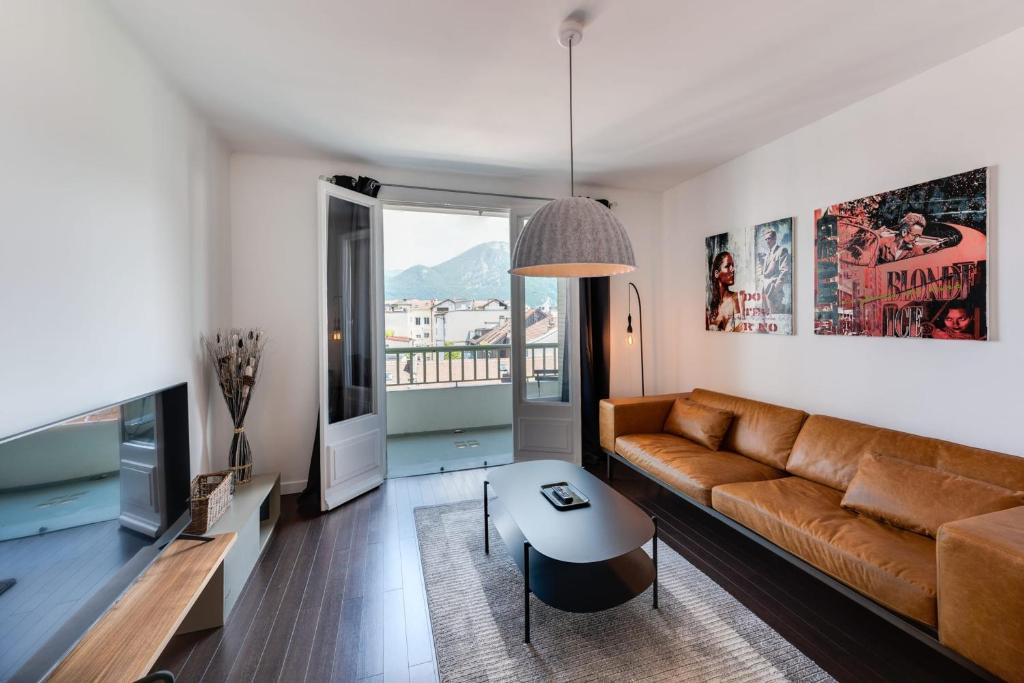 a living room with a couch and a table at Allure - 2 bedroom apartment with balcony in the centre of Annecy in Annecy