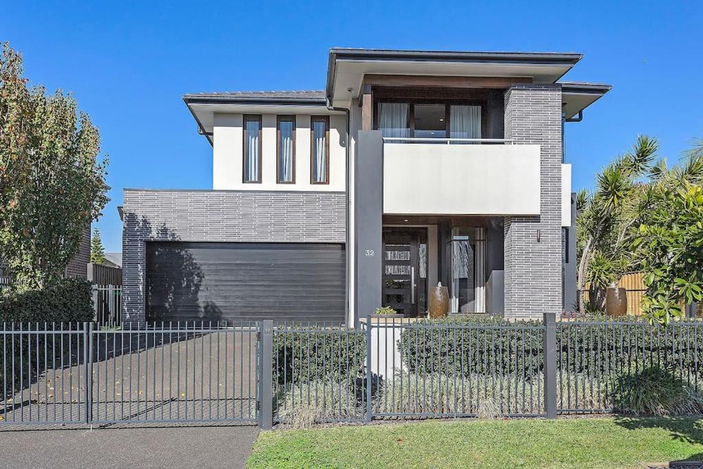 a house with a fence in front of it at Luxury Brand New Home in Shellharbour