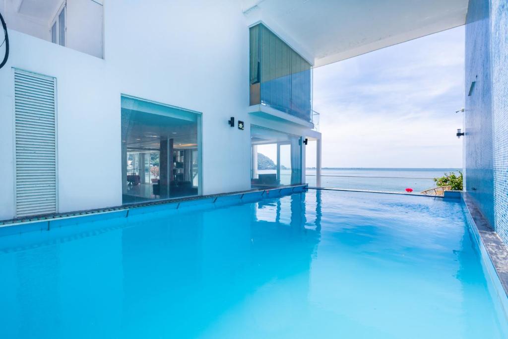 an infinity pool in a house with a view of the ocean at Palm Villa 23 (Beachfront Pool Villa Vung Tau with an Ocean view and Karaoke, Billards) in Vung Tau