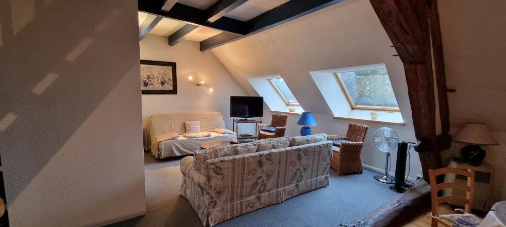sala de estar con sofá y TV en hebergement-luxeuil-les-bains, en Luxeuil-les-Bains