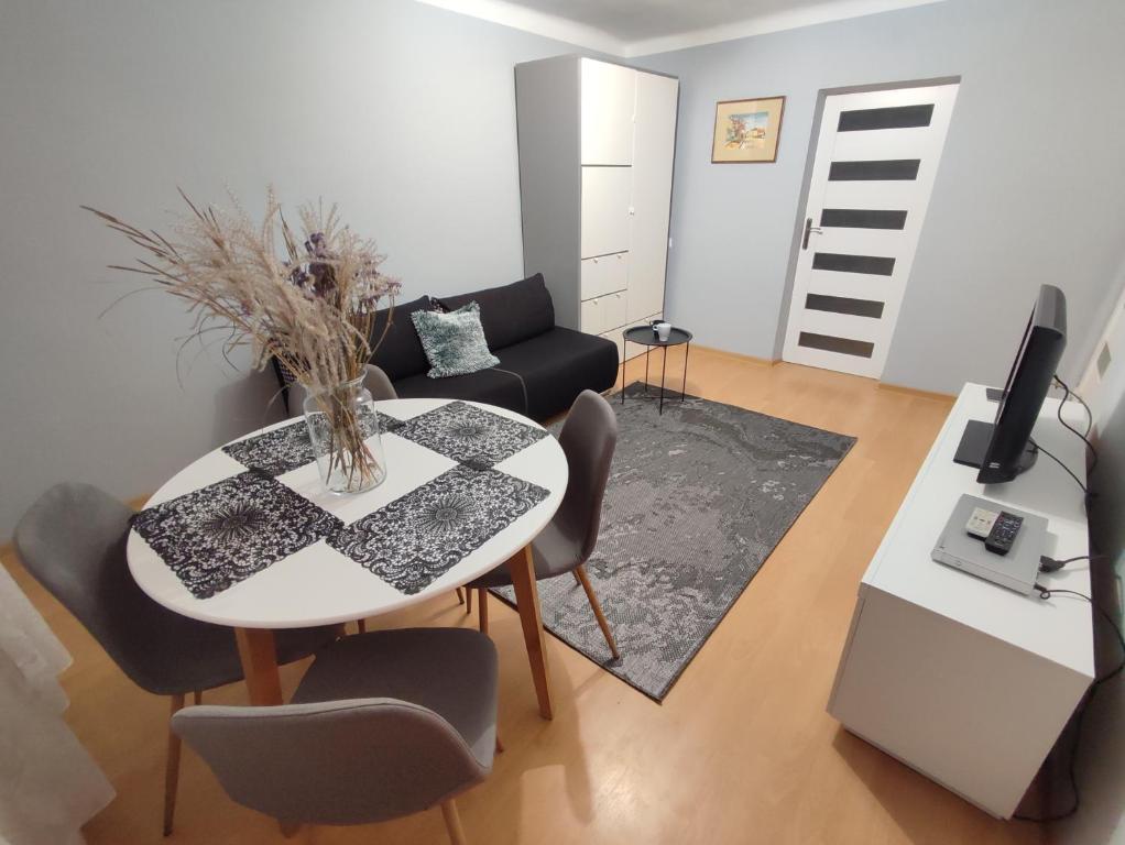 uma sala de estar com uma mesa e um sofá em Apartament Kwatera Oficera em Sandomierz