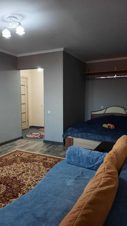 a bedroom with two beds and a rug at Уютные апартаменты в историческом центре in Aktobe