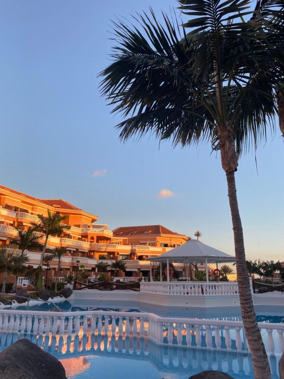 een resort met een palmboom en een zwembad bij Apartamento Las Vistas Beach - Tenerife Royal Gardens in Playa de las Americas