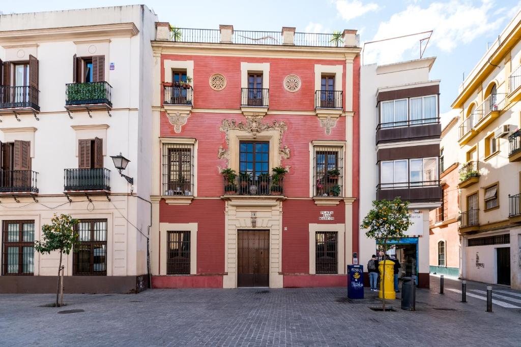 un edificio rojo y blanco en una calle en Veoapartment San Marcos, en Sevilla
