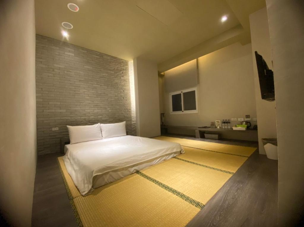 a bedroom with a white bed in a room at Kiwi Express Hotel-Taichung Station II in Taichung