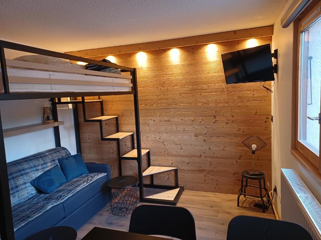 salon z łóżkiem piętrowym i telewizorem w obiekcie Studio cosy et chaleureux w mieście Valloire