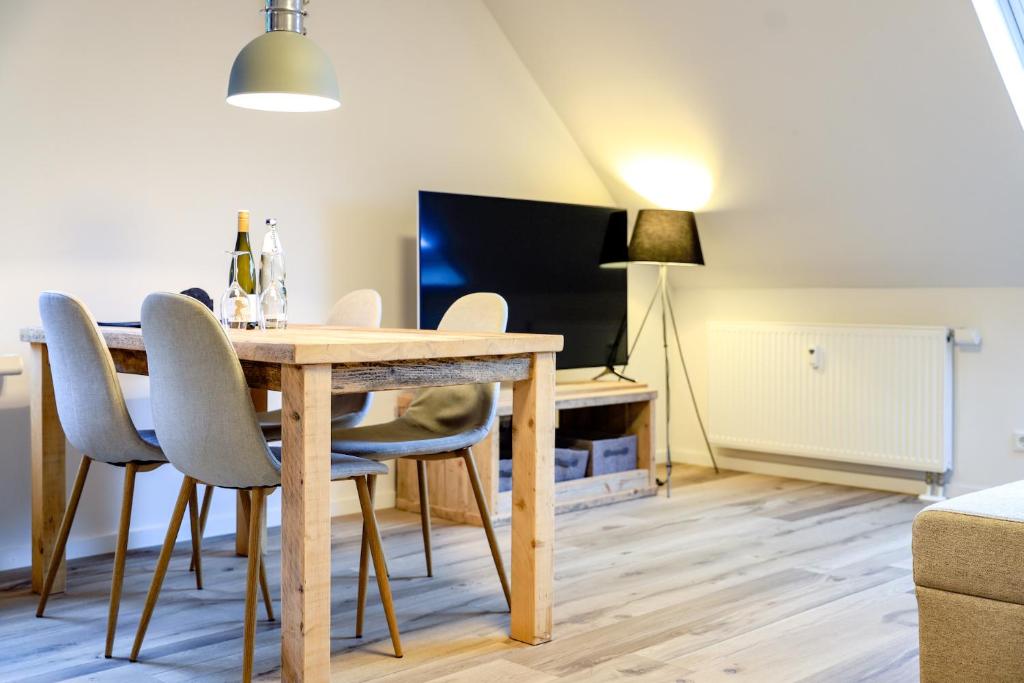 een eetkamer met een tafel, stoelen en een tv bij Smart Resorts Haus Opal Ferienwohnung 404 in Winterberg
