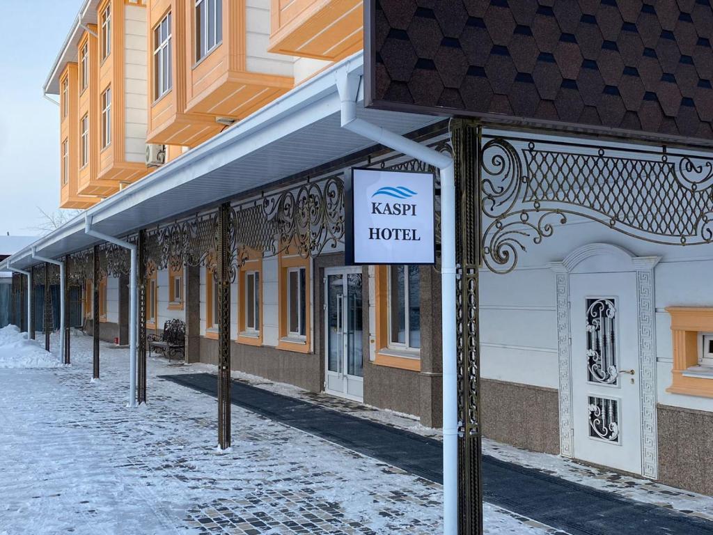 un cartel en una calle frente a un edificio en Kaspi Hotel, en Uralsk