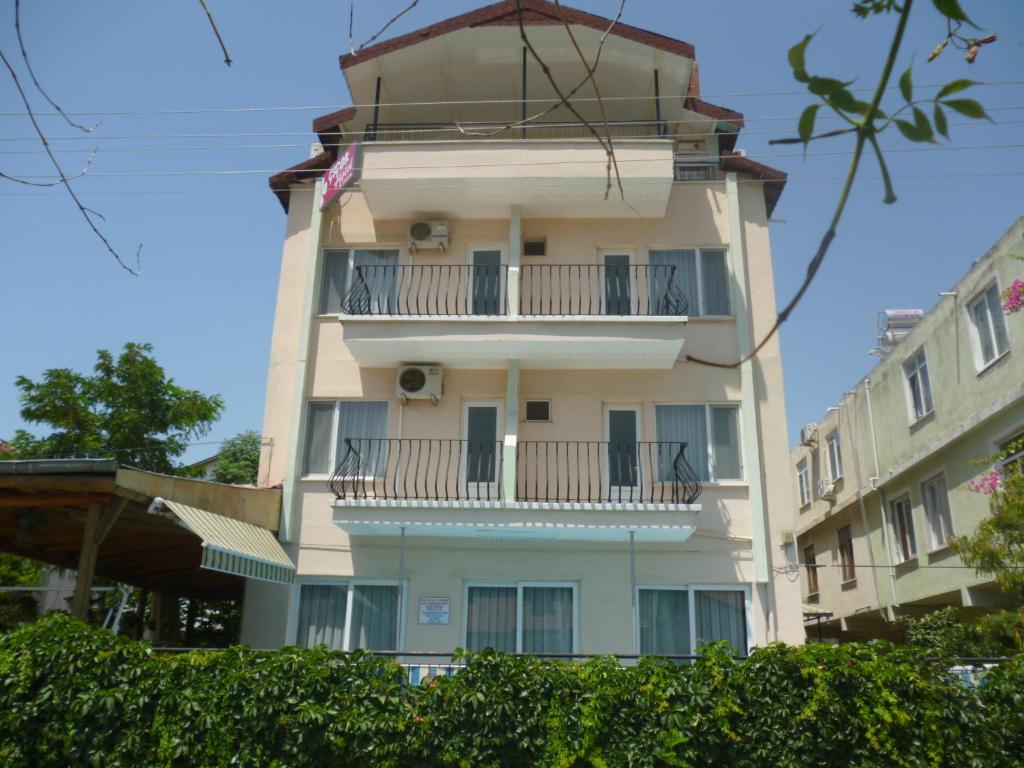 um edifício branco alto com uma varanda em Cicek Hotel & Apartments em Fethiye