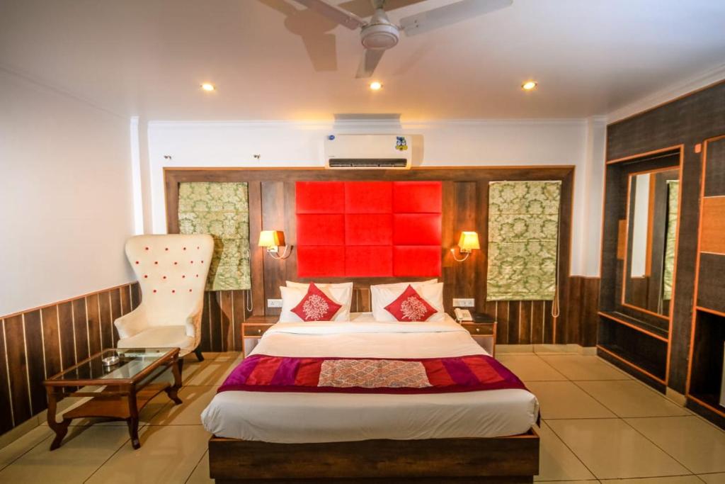 una camera d'albergo con letto e sedia di Little Mastiff Pong View a Dharamshala