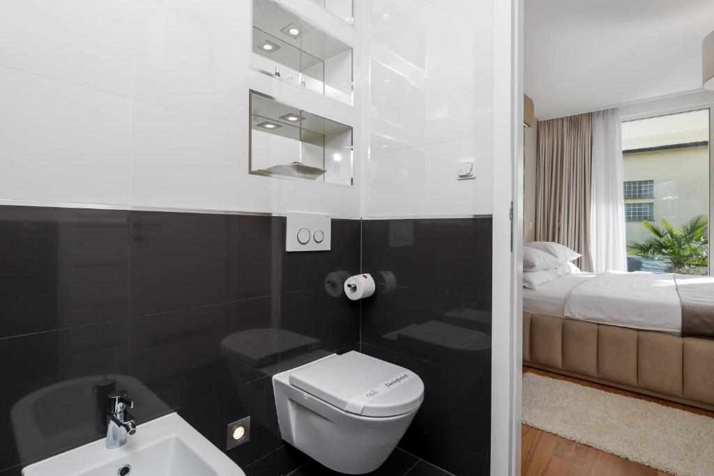 łazienka z toaletą, umywalką i łóżkiem w obiekcie Apartment Lara with rooftop swimming pool w mieście Ičići
