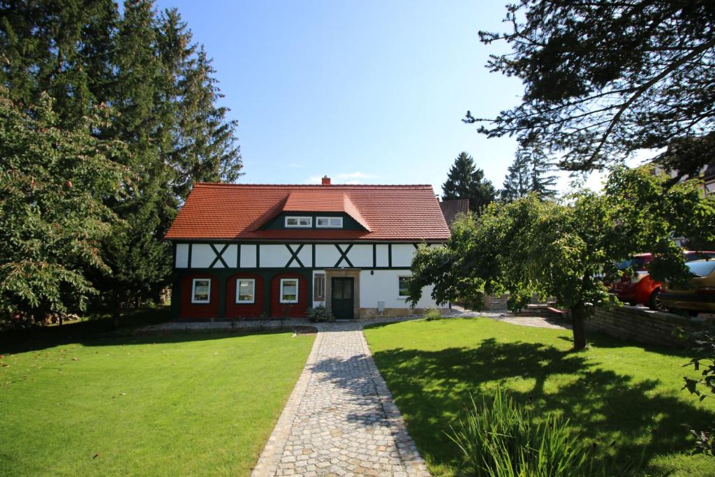 a house with a red roof on a green yard at Ferienwohnung Kurort Jonsdorf in Kurort Jonsdorf