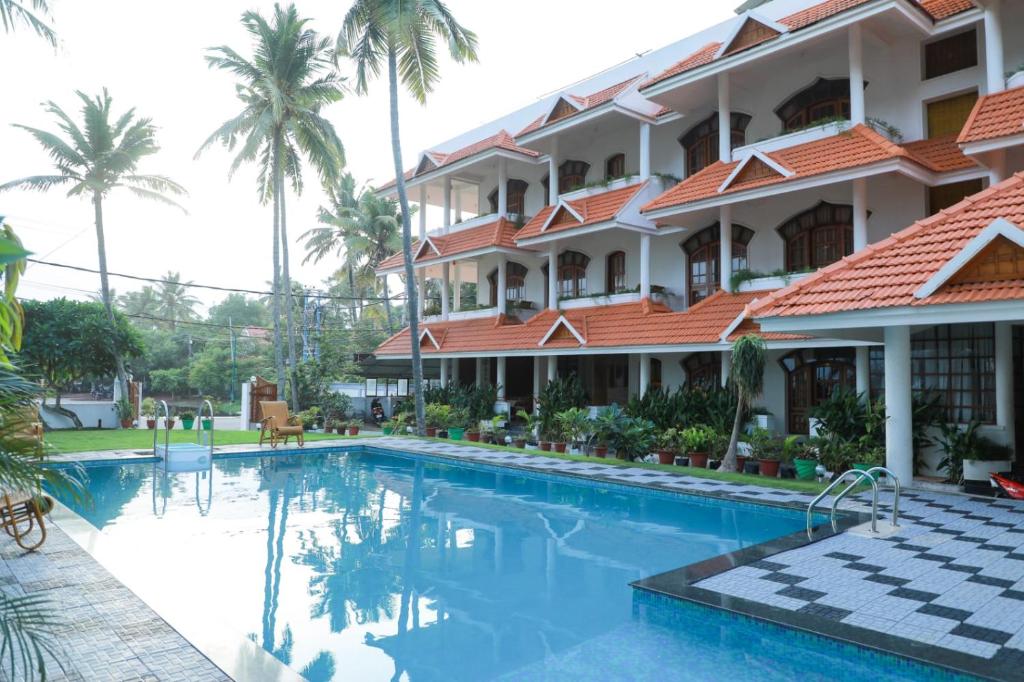 ein Hotel mit einem Pool vor einem Gebäude in der Unterkunft The Sanctum Spring Beach Resort in Varkala