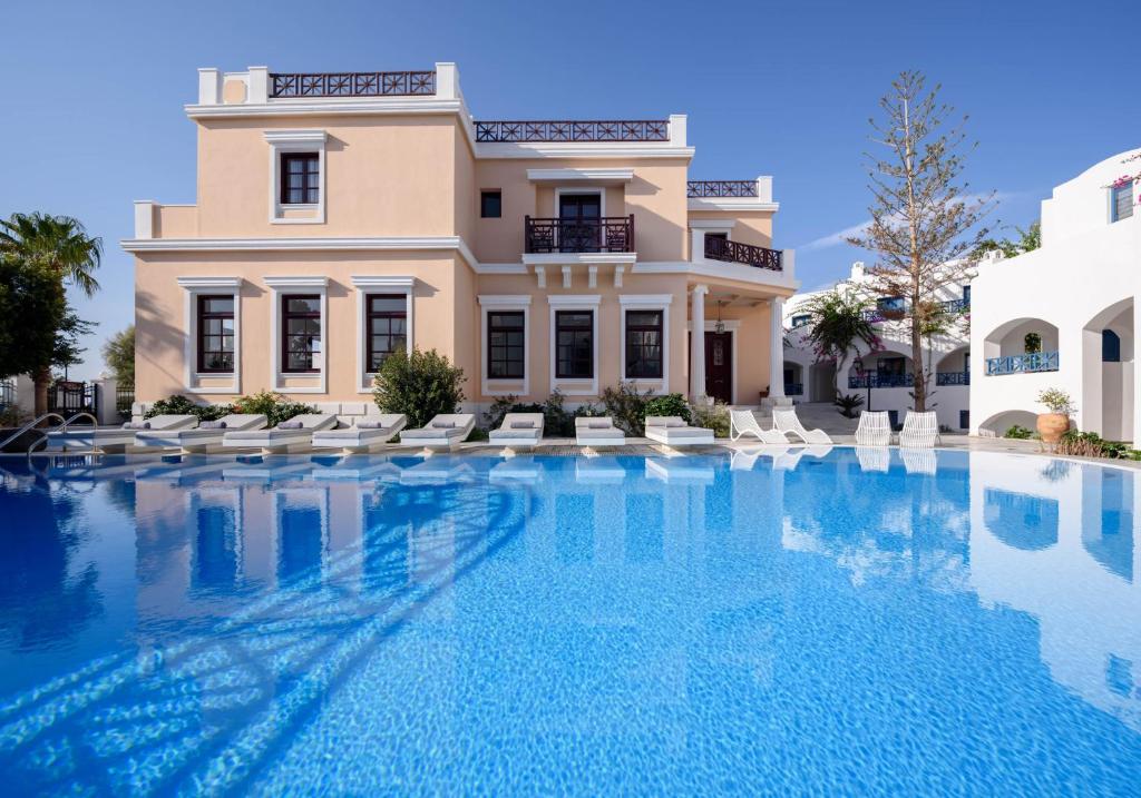 a large swimming pool in front of a building at Veggera Beach Hotel in Perissa