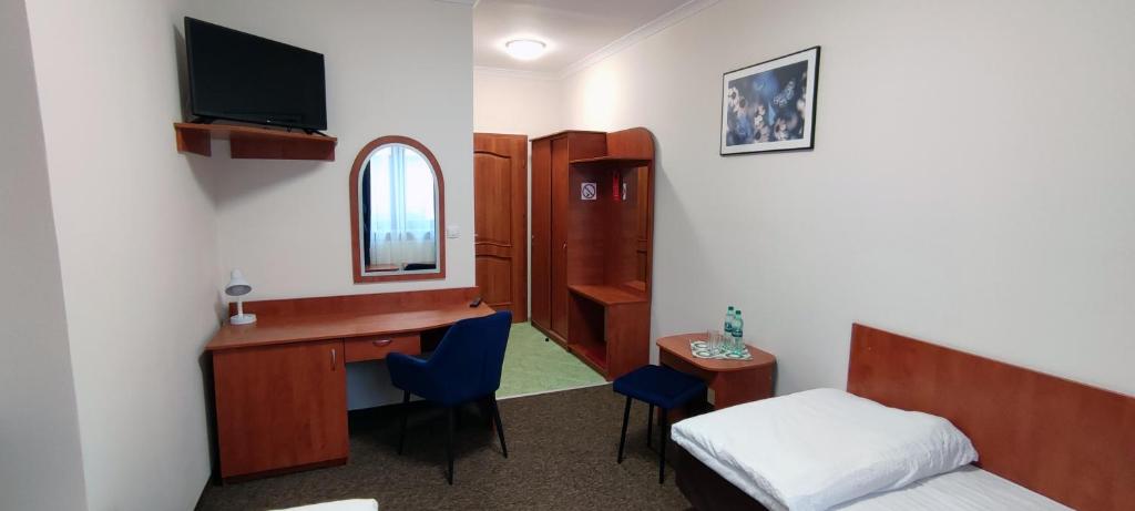 um quarto com uma cama e uma secretária com um espelho em Motel Port 2000 em Mostki