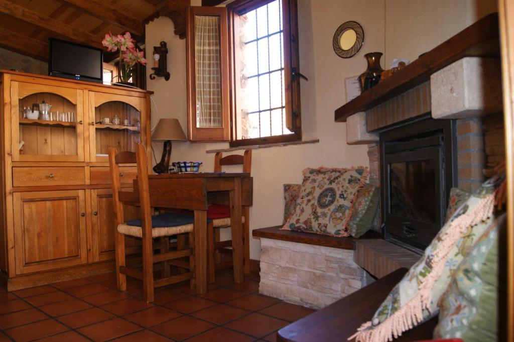 ein Wohnzimmer mit einem Tisch und einem Kamin in der Unterkunft casa rural Aaiun in Riópar