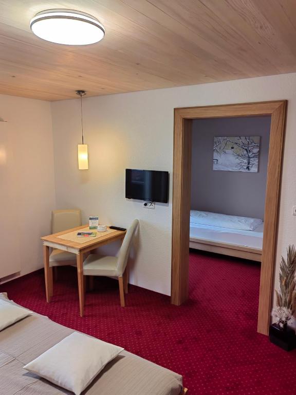 una camera d'albergo con tavolo e letto di Frühstückspension Bilgeri a Sulzberg