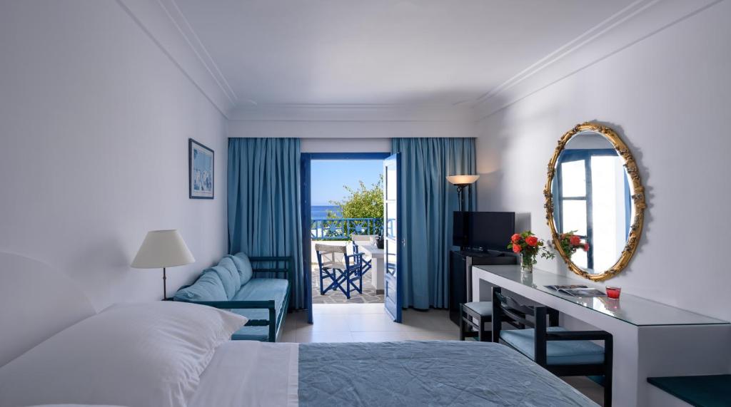 A bed or beds in a room at Veggera Beach Hotel