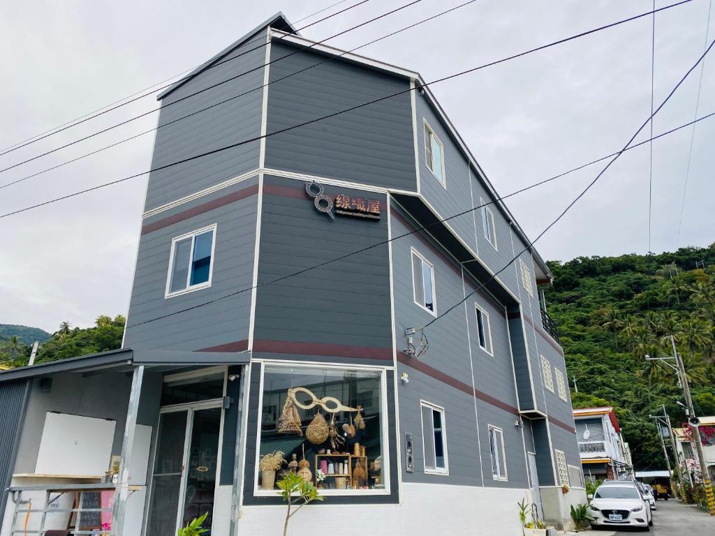 um edifício cinzento com um sinal nele em 太麻里金崙線織屋背包房Line Weaving House B&B em Taimali