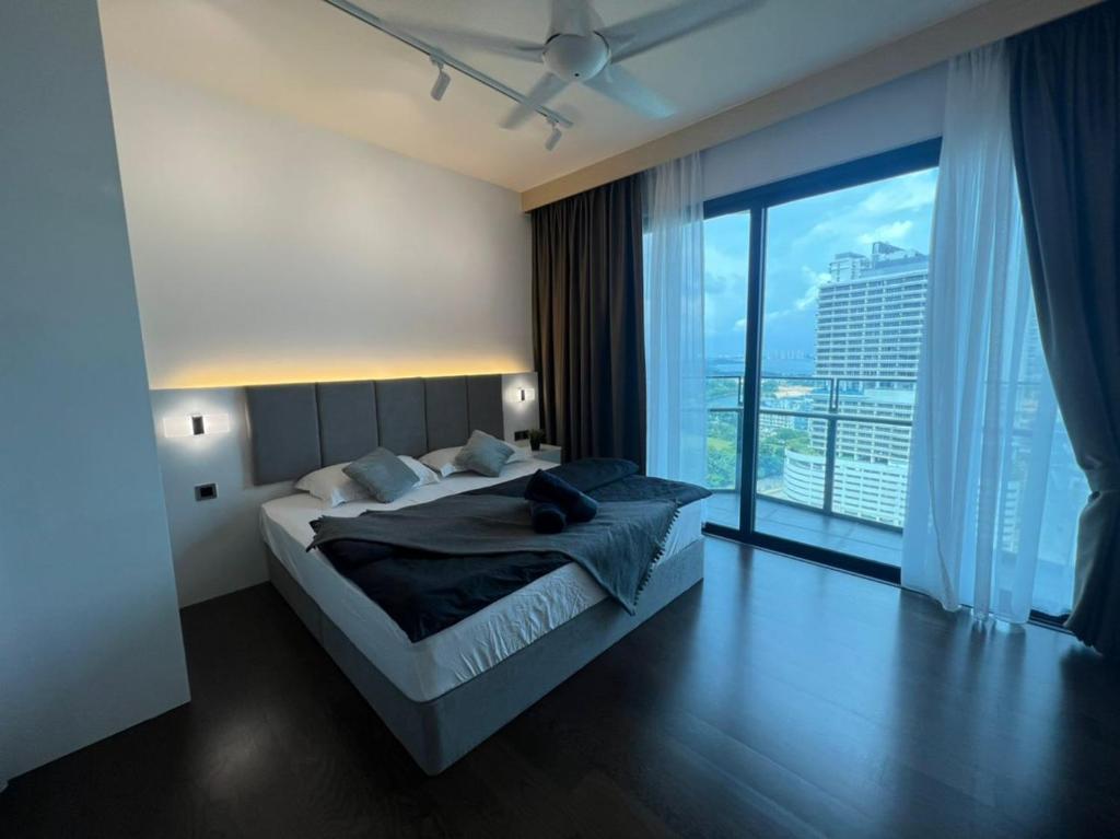 ein Schlafzimmer mit einem großen Bett und einem großen Fenster in der Unterkunft Almas Suite Puteri Harbour-T- Legoland-JB新山- SG新加坡 in Nusajaya