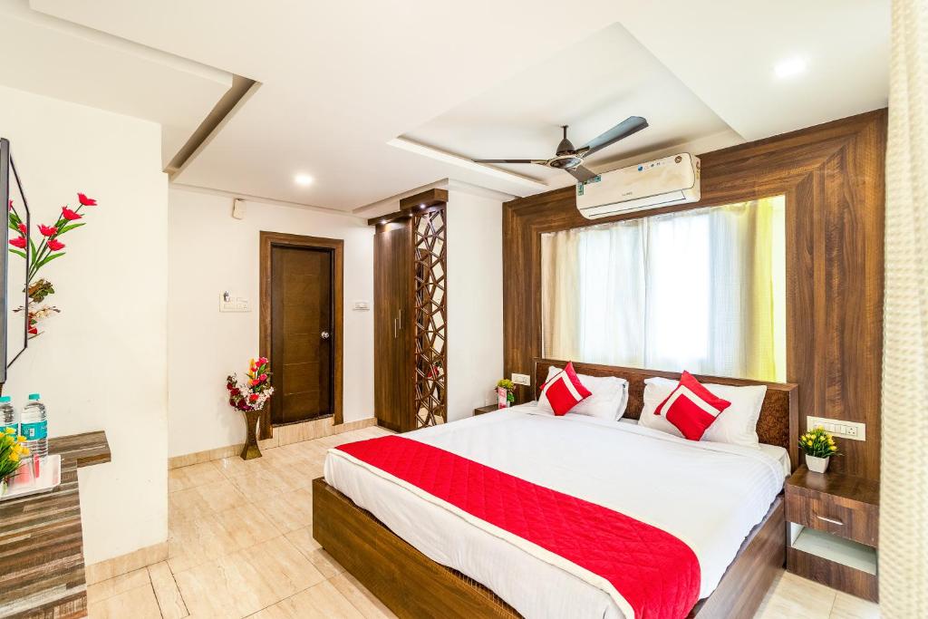 a bedroom with a large bed with red pillows at Octave Kings Suites in Bangalore