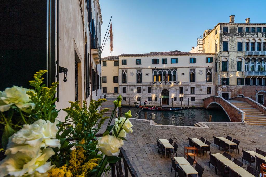 vistas a un canal con edificios y un barco en Locanda Sant'Agostin, en Venecia