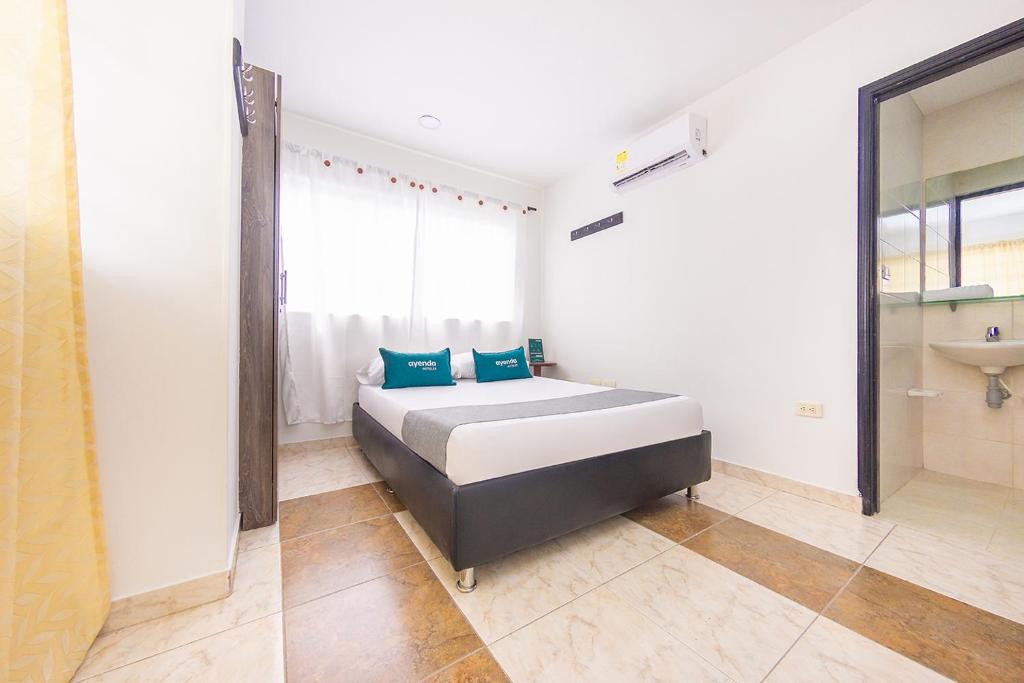 a bedroom with a bed and a sink in it at Ayenda Villa Marta in Cartagena de Indias