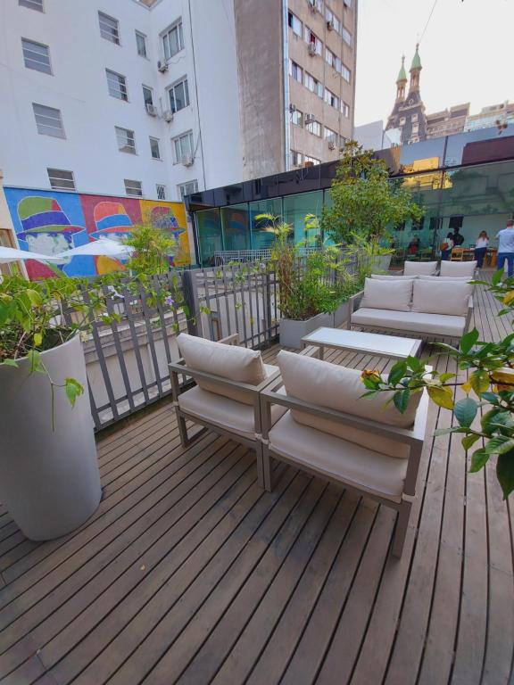 ブエノスアイレスにあるCassa Lepage Art Hotel Buenos Airesの建物内の椅子と植物のあるデッキ