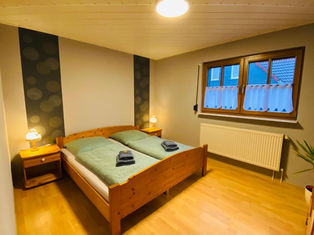 una camera con letto e finestra di Ferienwohnung An den Erlewiesen, 3SZ, 85qm, Kamin a Schleusingen