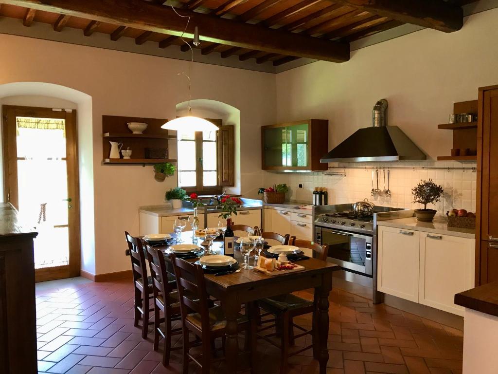 cocina con mesa de madera y sillas en Agriturismo Podere Filicaia, en San Giovanni Valdarno