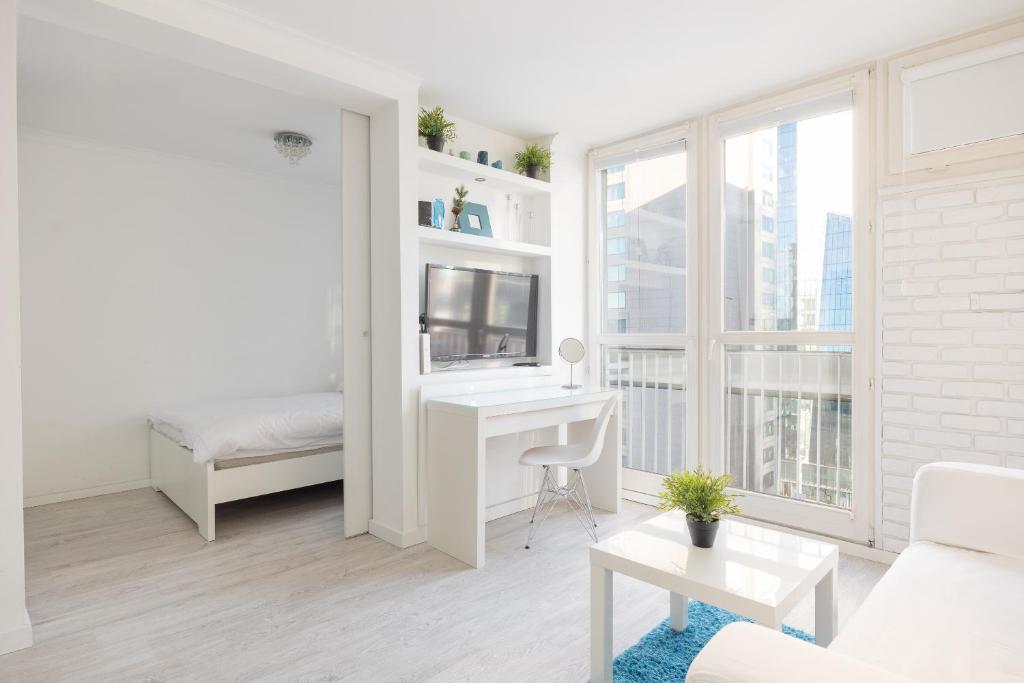 Biały salon z biurkiem i łóżkiem w obiekcie Rondo ONZ Business Apartment w Warszawie