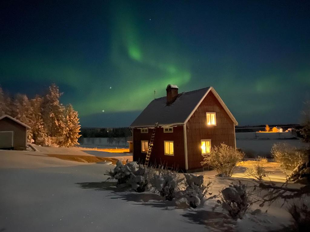 una casa con la aurora en el cielo en COZY Home with LAKE view-free WiFi - free SAUNA, en Överkalix