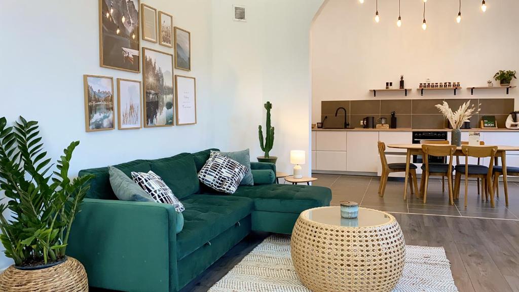 ein Wohnzimmer mit einem grünen Sofa und einem Tisch in der Unterkunft Direkter Moselblick 126m² großer Altbau und Terrasse in Sankt Aldegund