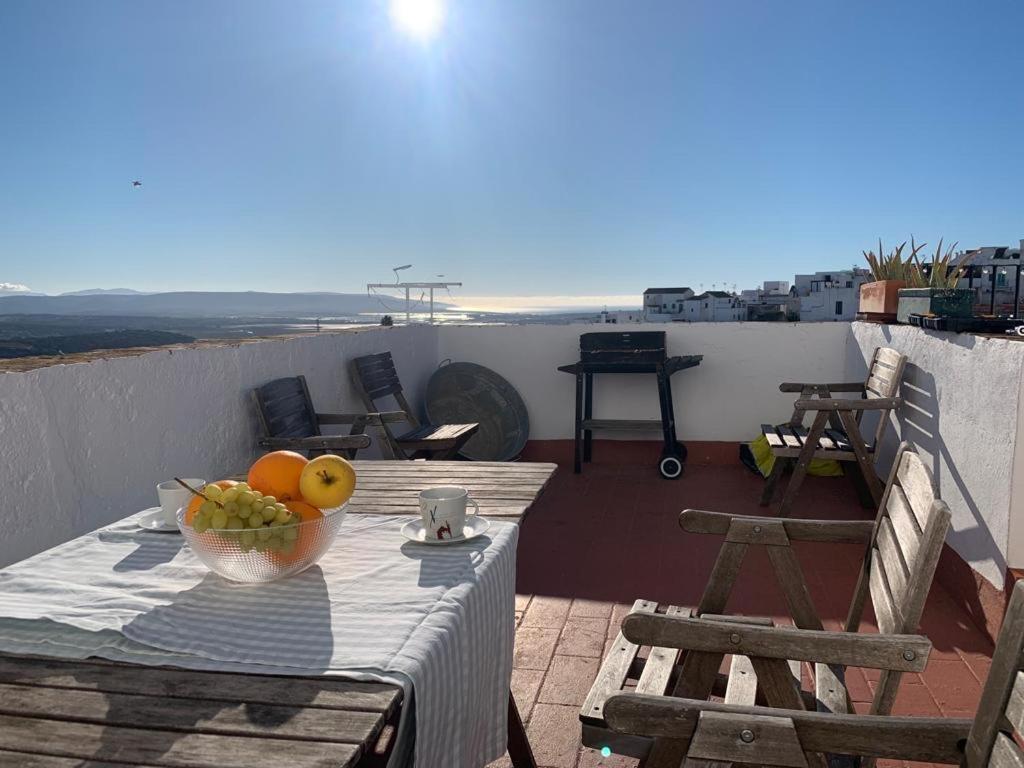 a table with a bowl of fruit on a balcony at El Almizcate in Vejer de la Frontera