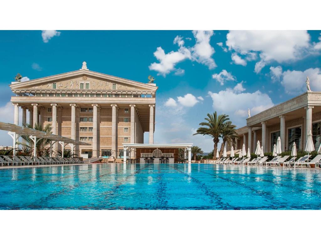 a large swimming pool in front of a building at Kaya Artemis Resort & Casino in Vokolidha