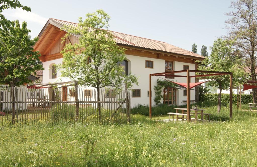 una casa con una valla y un parque infantil en Ansitz Parstorfer, en Chieming