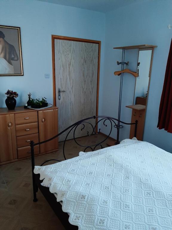 a bedroom with a bed and a dresser at Krémer Vendégház in Harkány
