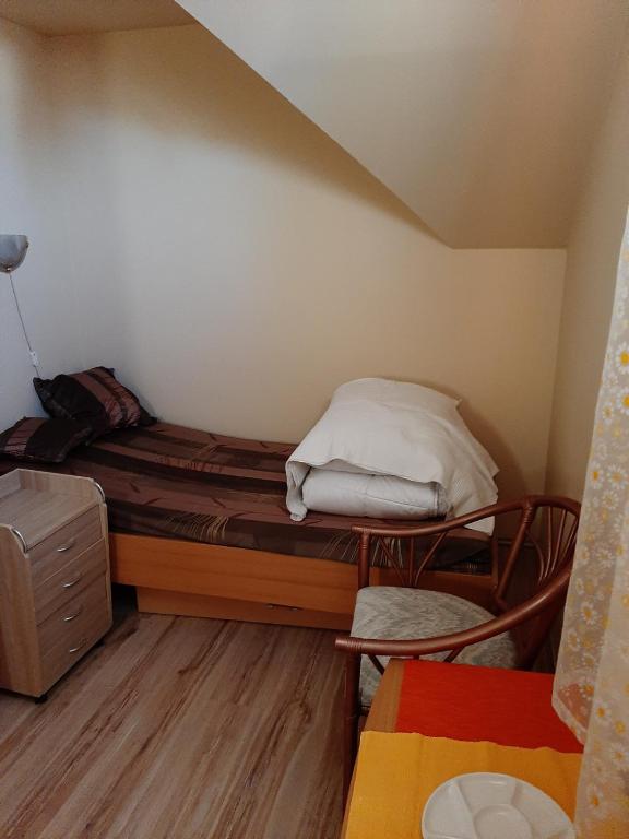 a small room with a bed with a pillow on it at Krémer Vendégház in Harkány