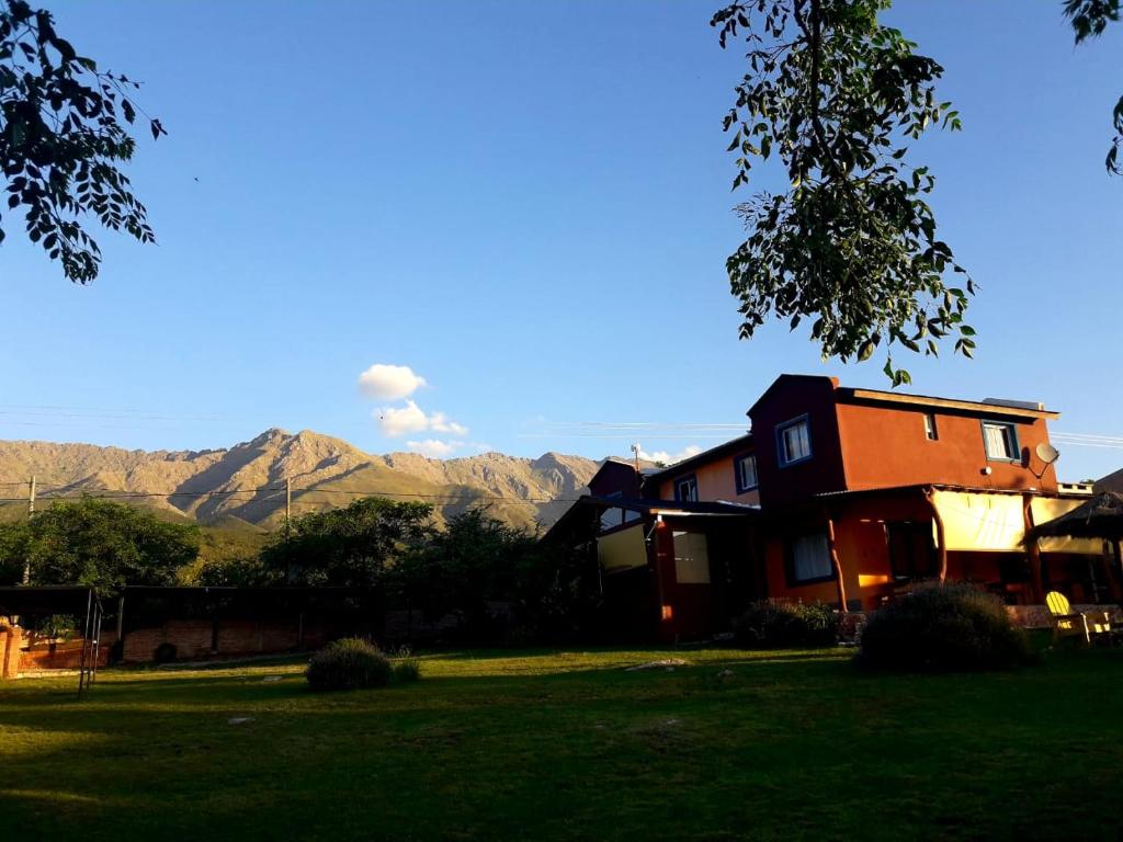 una casa en un patio con montañas al fondo en Sierra Magenta en Los Hornillos