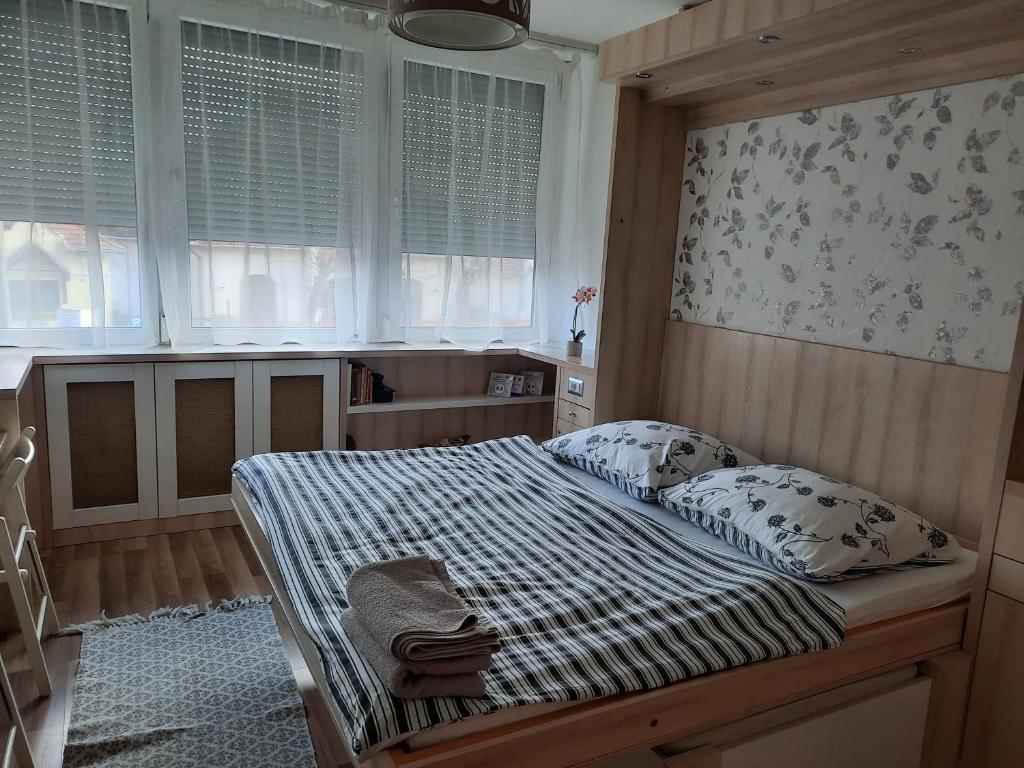 a bedroom with a bed and two pillows on it at Mikes Apartman in Szekszárd