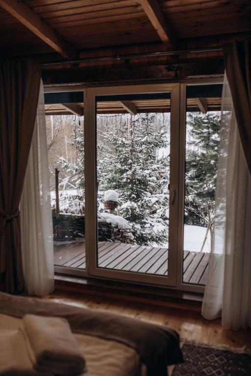 a bedroom window with a view of a snow covered yard at Dolyna Mykolaya in Migovo